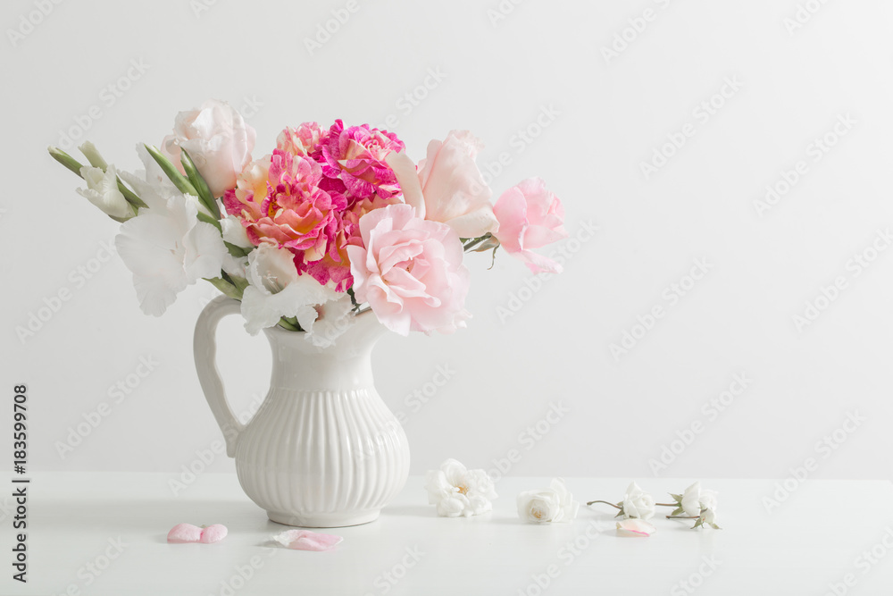 pink and white flowers in vase on white background