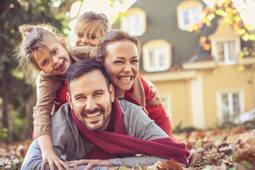 Happy family lying in autumn leaves.