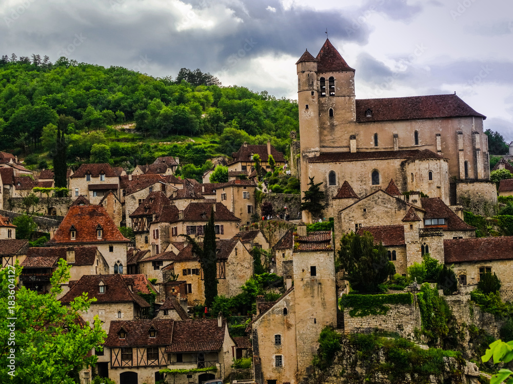 Saint Cirq Lapopie fortified medieval church in France on a cloudy day.
