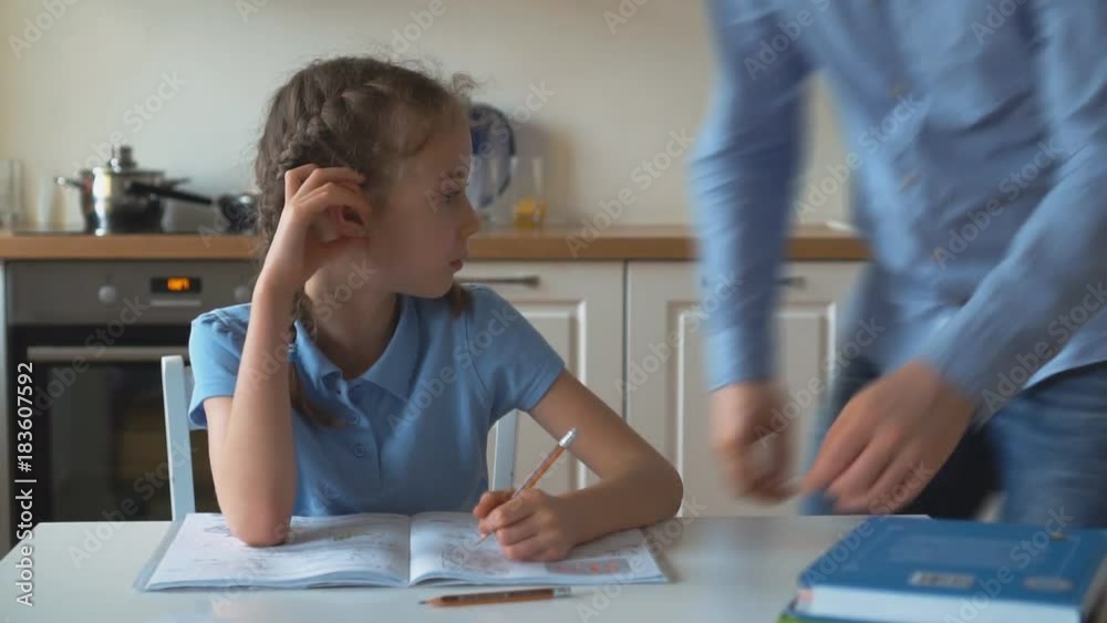 Father helping daughter with homework at home. Father helping daughter with homework at home.