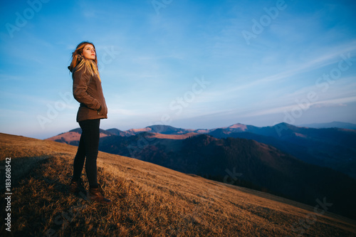 Shot of a young woman looking at the landscape while hiking in the mountains. Girl tourist in mountain. Recreation fitness and healthy lifestyle outdoors in beautiful nature.