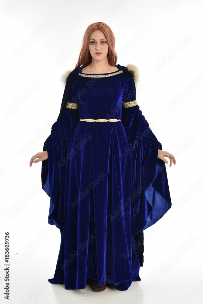 full length portrait of girl wearing long blue velvet gown and fur lined cloak, standing pose  on white background.