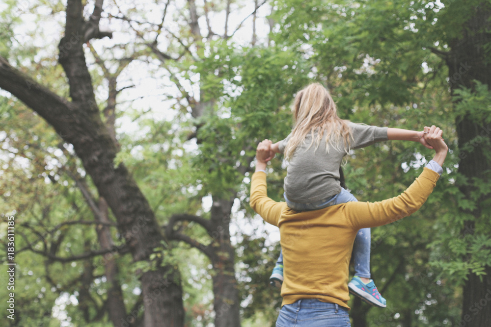 Mother with her daughter playing in nature. From back. Mother with her daughter playing in nature. From back.