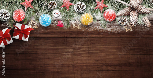 Christmas decoration with presents at top of wooden desk sprinkled with snowflakes, free space for text
