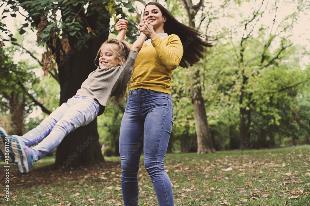 Smiling mother and daughter playing in nature. On the move. Smiling mother and daughter playing in nature. On the move.