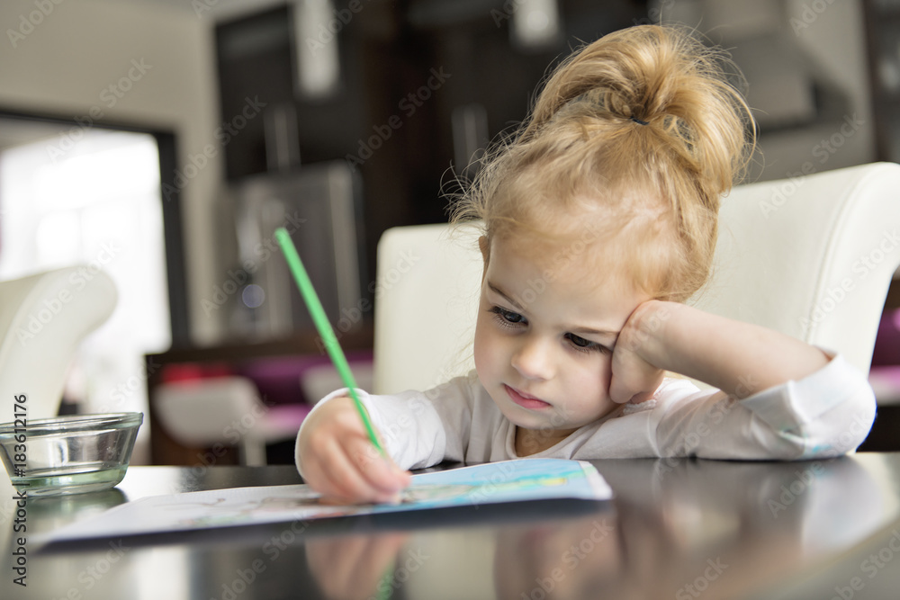 girl painting on the kitchen table at home girl painting on the kitchen table at home