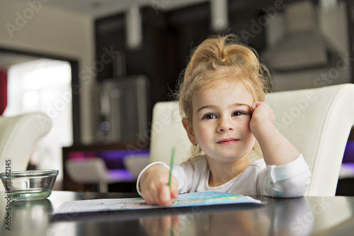 girl painting on the kitchen table at home
