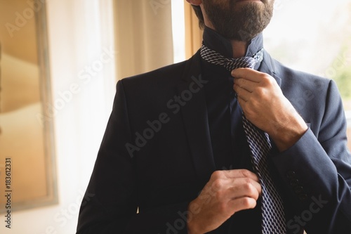 Man wearing his tie at home photo