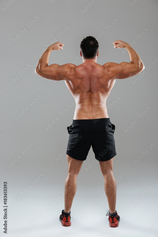 Obraz premium Back view full length portrait of a strong male bodybuilder