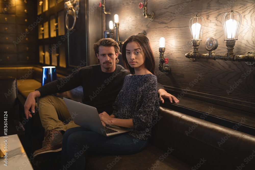 Couple using laptop in chocolate bar Couple using laptop in chocolate bar