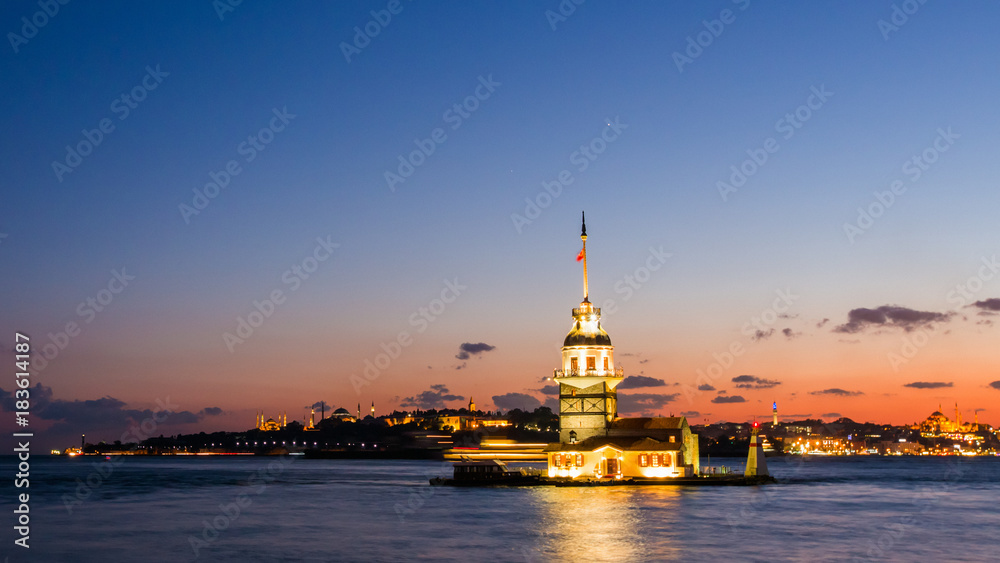 Maiden Tower or Kiz Kulesi with floating tourist boats on Bosphorus in Istanbul at night