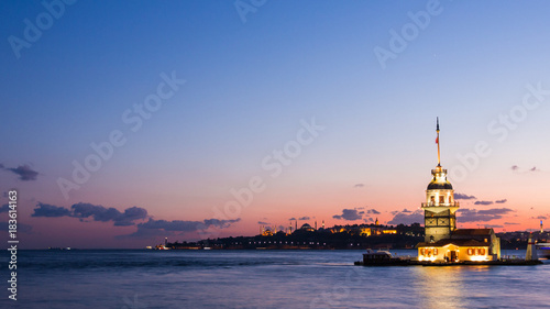 Maiden Tower or Kiz Kulesi with floating tourist boats on Bosphorus in Istanbul at night