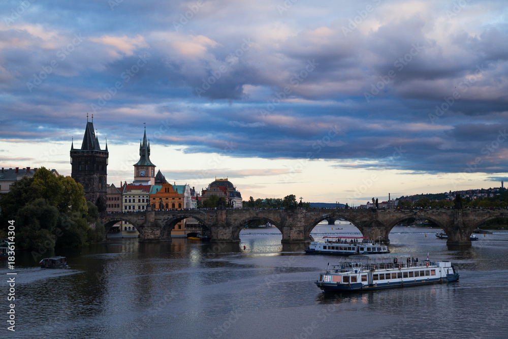 Obraz premium Panoramic view on Vltava river with ships and ferryboat along it and historical center of Prague,buildings and landmarks of old town, Prague, Czech Republic. Beautiful Prague at Twilight.