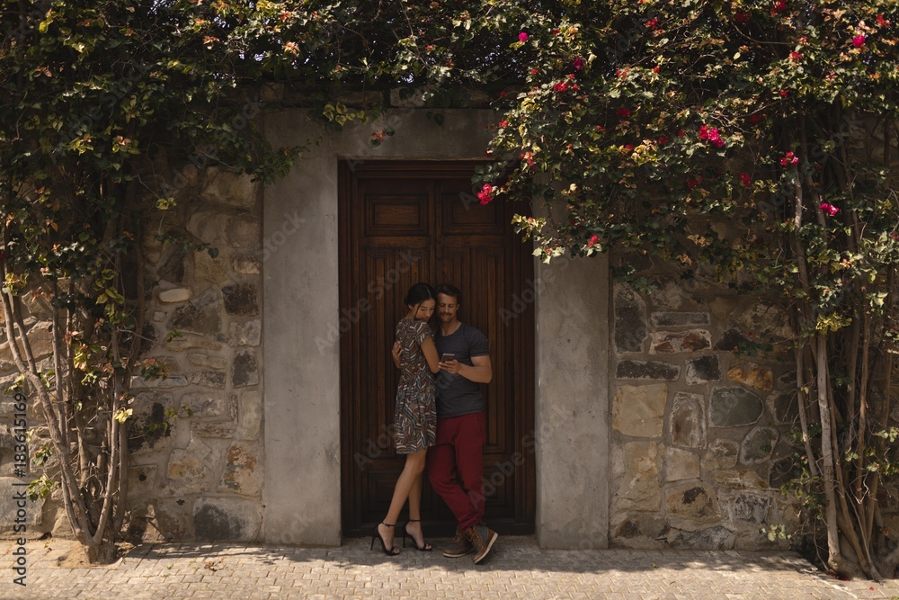Couple embracing each other against door Couple embracing each other against door