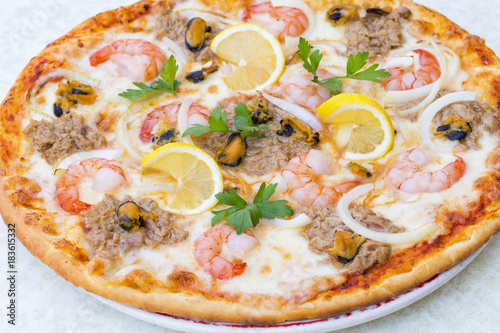 Sea gifts pizza with shrimps, mussels and tuna fish. Top view