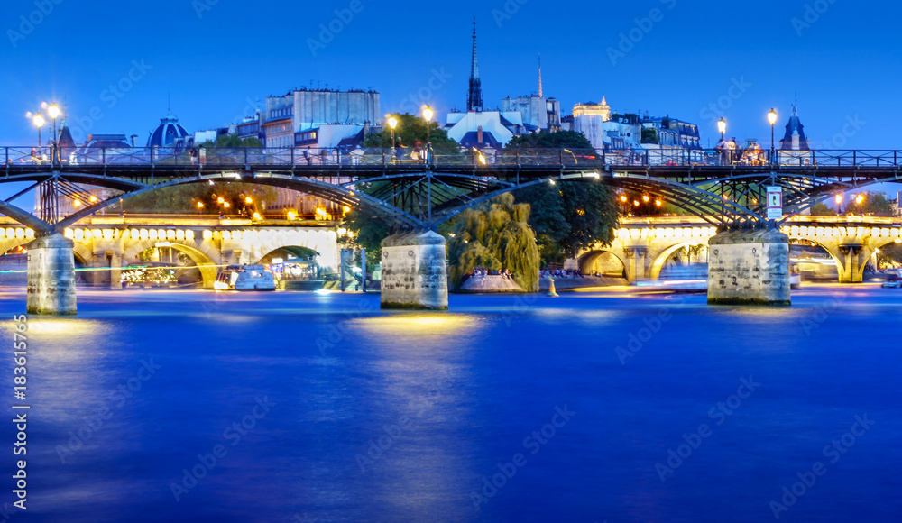 Love Bridge called Pont des Arts on a famous beautiful La Seine river in Paris, France. Best tourists destination in Europe. Taken by long exposure by night photography. Landmark in Paris and historic