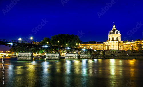 Love Bridge called Pont des Arts on a famous beautiful La Seine river in Paris, France. Best tourists destination in Europe. Taken by long exposure by night photography. Landmark in Paris and historic