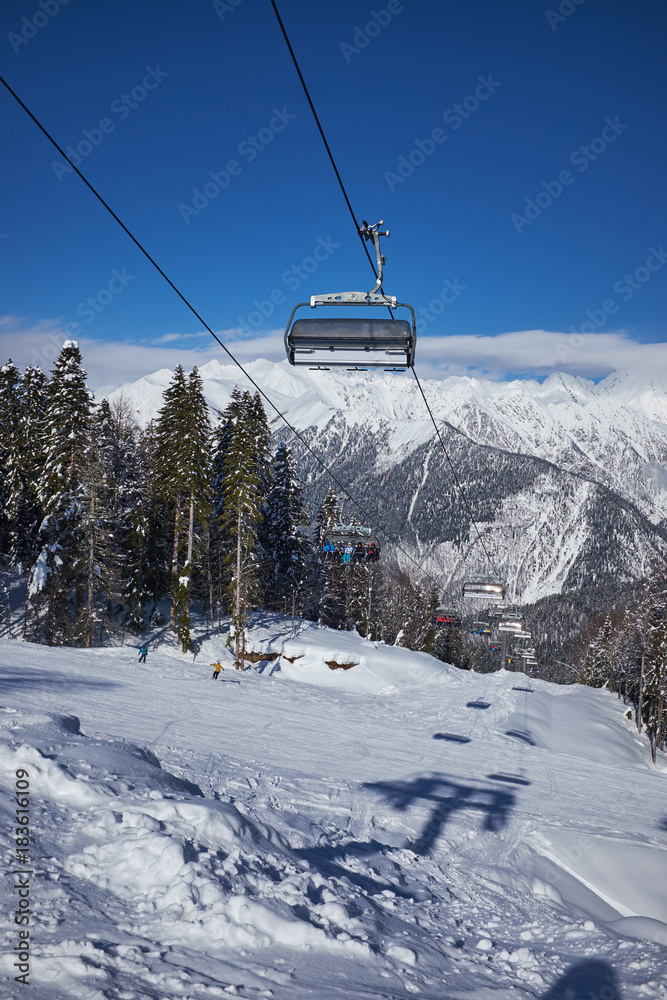 Skiers on the chairlift - ski resort during winter sunny day