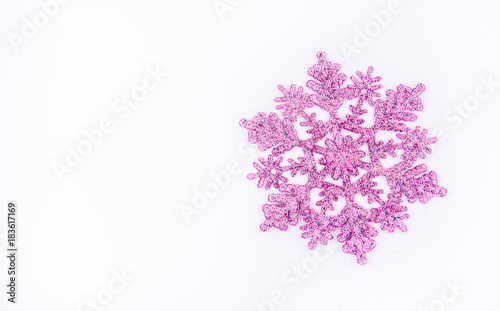 Shiny pink snowflake on white background. Decoration for Christmas tree. Copy space