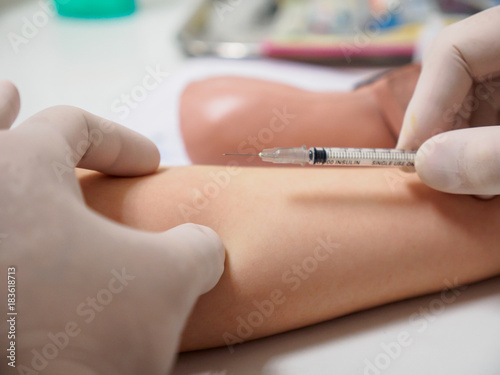 A physician holds a syringe needle above a diabetic patient's arm after an insulin injection. Healthcare and metabolic syndrome concept. photo