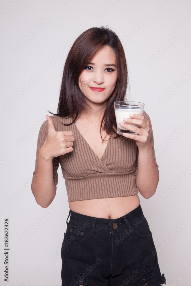 Healthy Asian woman drinking a glass of milk thumbs up. Healthy Asian woman drinking a glass of milk thumbs up.