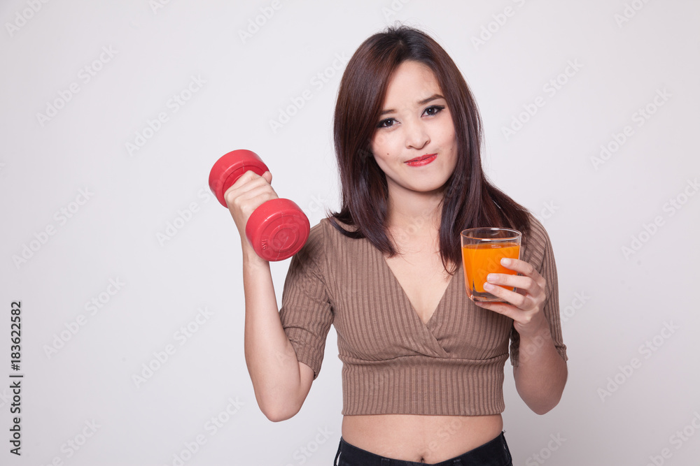 Young Asian woman with dumbbell drink orange juice. Young Asian woman with dumbbell drink orange juice.