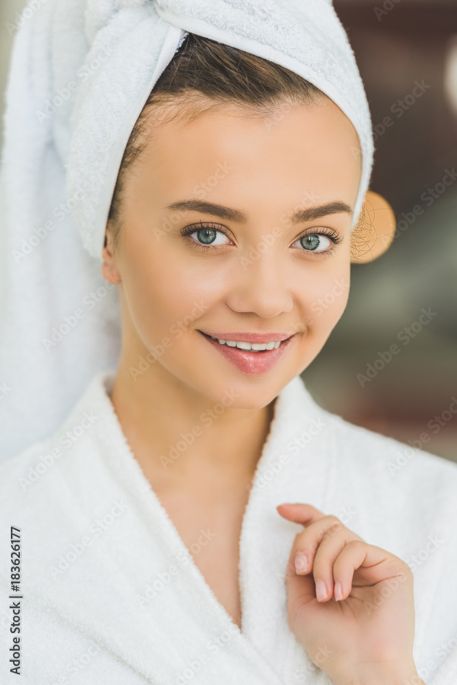 close-up portrait of beautiful young woman in bathrobe and towel on head at spa salon close-up portrait of beautiful young woman in bathrobe and towel on head at spa salon