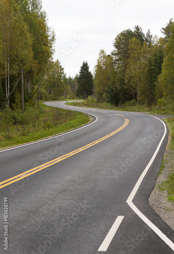 Curvy asphalt road on autumn day in Finland. Yellow lines and clean road. Highway to drive. © Jne Valokuvaus