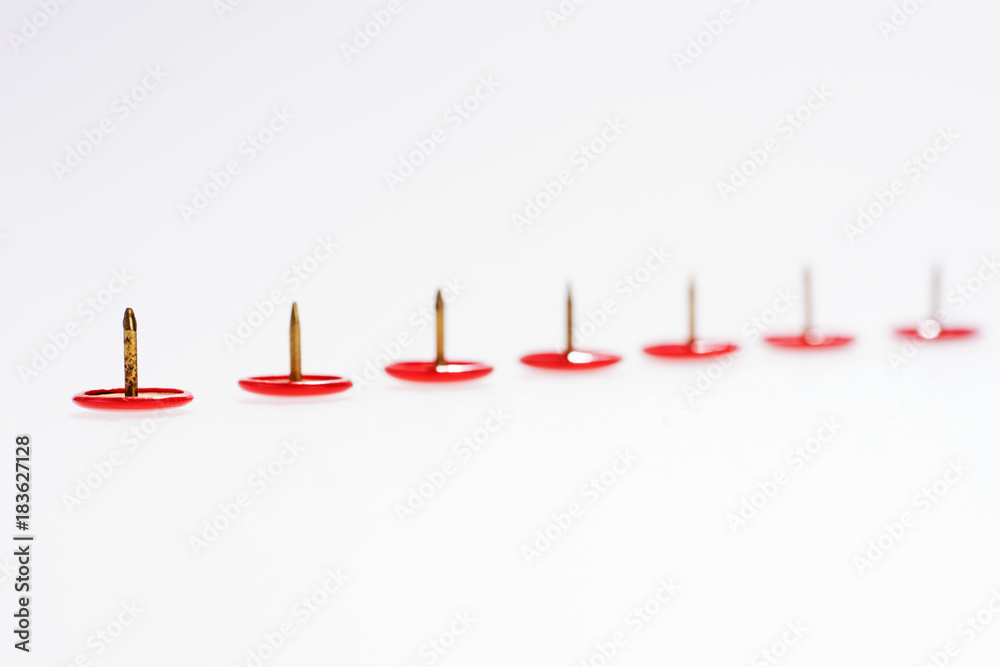 Row of red thumbtacks isolated on white background Row of red thumbtacks isolated on white background