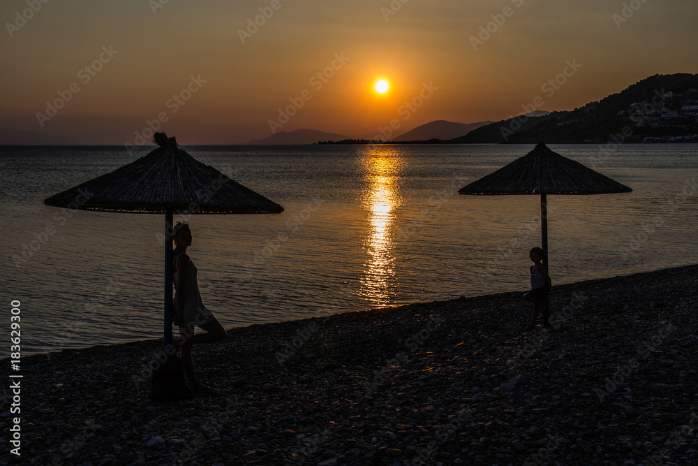 Fototapeta premium sunset and silhouettes under the umbrella