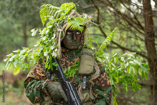 Camouflaged soldiers in forest during early spring on patrol