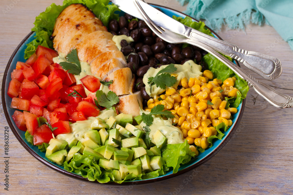 Grilled chicken with avocado, tomatoes, sweet corn, beans and lettuce. Southwestern colorful chicken salad with creamy cilantro dressing. horizontal Grilled chicken with avocado, tomatoes, sweet corn, beans and lettuce. Southwestern colorful chicken salad with creamy cilantro dressing. horizontal