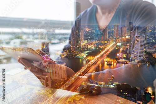 Double Exposure of Man or Male hold Digital Wireless Tablet with City Building