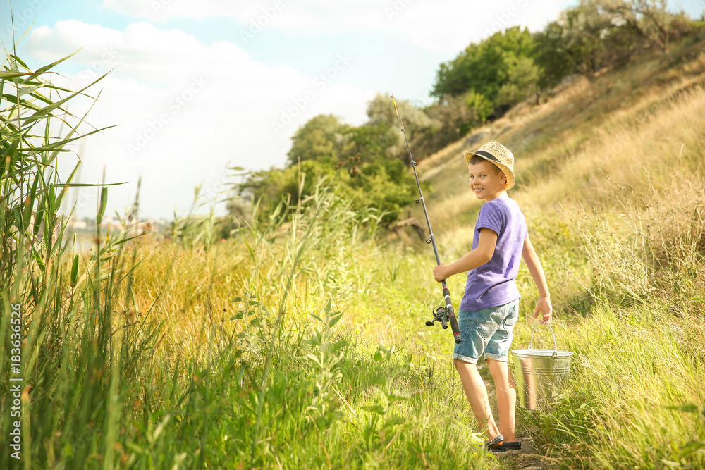 Cute boy going fishing on summer day