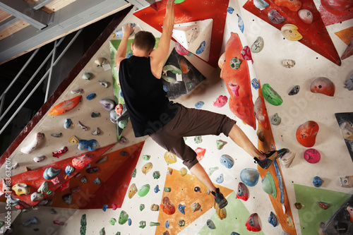 Young man exercising in climbing gym