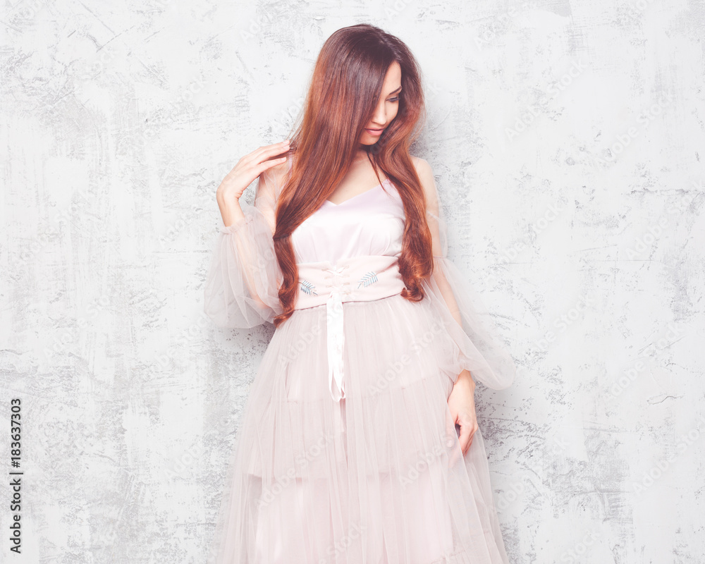 Portrait of a long-haired girl posing against a gray stone wall. Red-haired beauty Portrait of a long-haired girl posing against a gray stone wall. Red-haired beauty