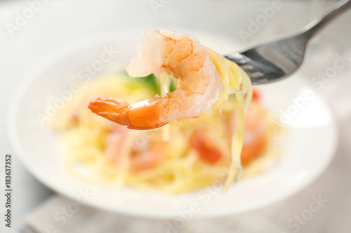 Fork with tasty pasta and shrimp, closeup