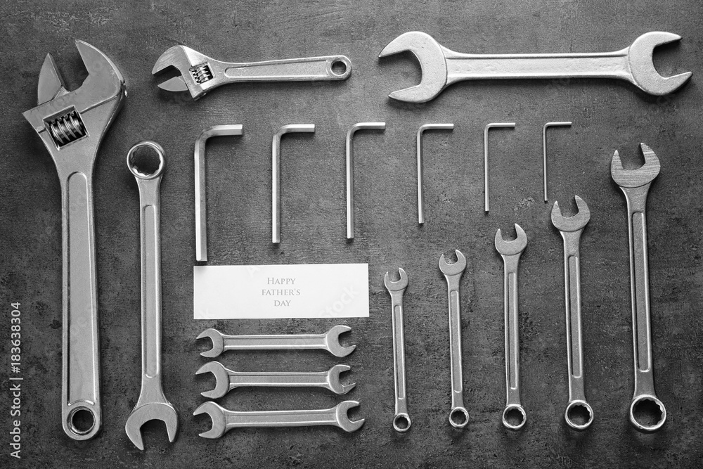Φωτογραφία Card with text Happy Father's Day and combination wrenches on gray background
