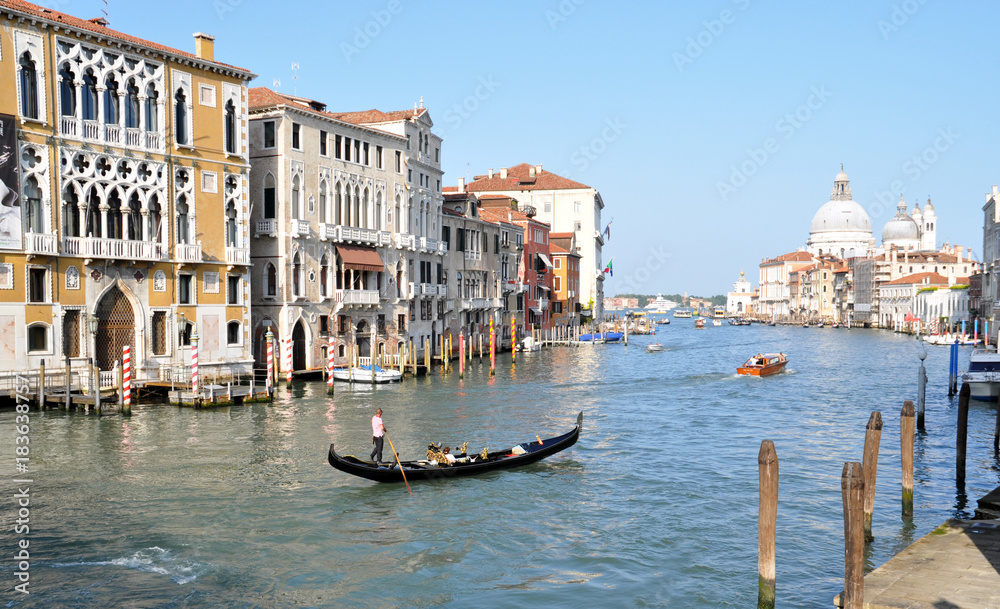a gondola sails along the beautiful Grand canal, the Basilica di Santa Maria della Salute in Venice, Italy