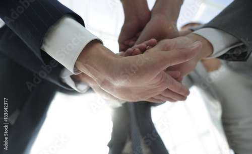 business people folding their hands together.
