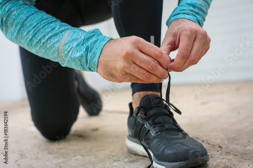 Sportsman tying shoelaces before running.