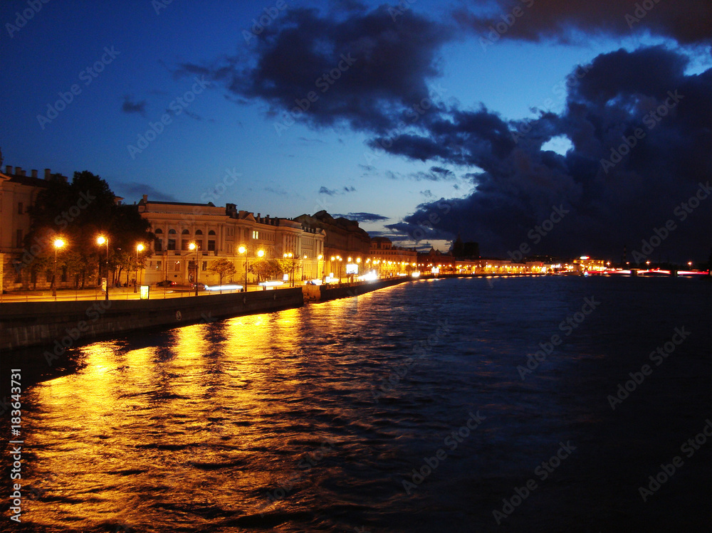 Illuminated embankment of river Neva in the summer night. Panorama quay of old St. Petersburg, Russia.