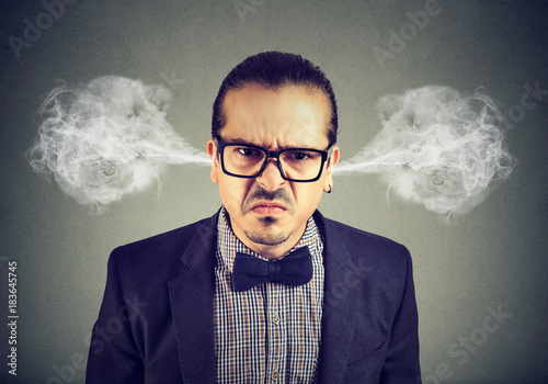 Angry business man, blowing steam coming out of ears, about to have nervous breakdown isolated on gray background. Negative emotions facial expression feelings