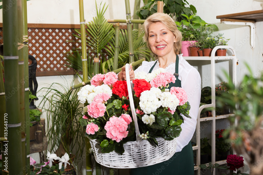 Cheerful female florist holding a basket