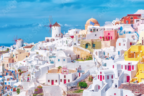 Stunning, amazing and beautiful classic white and caramel color Greek architecture with unbelievable wind mills on Santorini volcano Cyclades Caldera island in warm waters of Aegean sea in Greece.