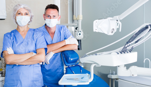 Portrait of two friendly professional dentists standing in medical office