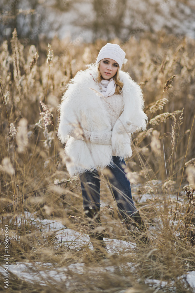 The girl in white furry coat stands in the middle reeds in the winter 9136. The girl in white furry coat stands in the middle reeds in the winter 9136.