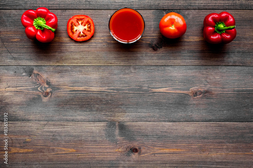 Red detox beverage with paprika and tomatoes on dark wooden background top view copyspace