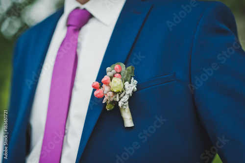 A boutonniere on the lapel of the groom 9254.