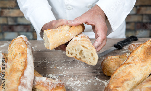 baker cutting traditional bread french baguettes